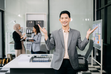 Attractive Asian male office worker business suits smiling at camera in office . teamwork startup concept