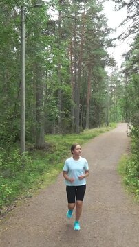 Athletic young woman running in a national park in Finland, doing sports in the park, staying fit by exercising