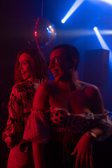 Two young women dancing together under vibrant lighting in a nightclub