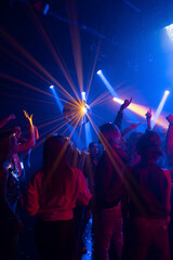A group of women and men have fun in dance party. Group of young people dancing in night club