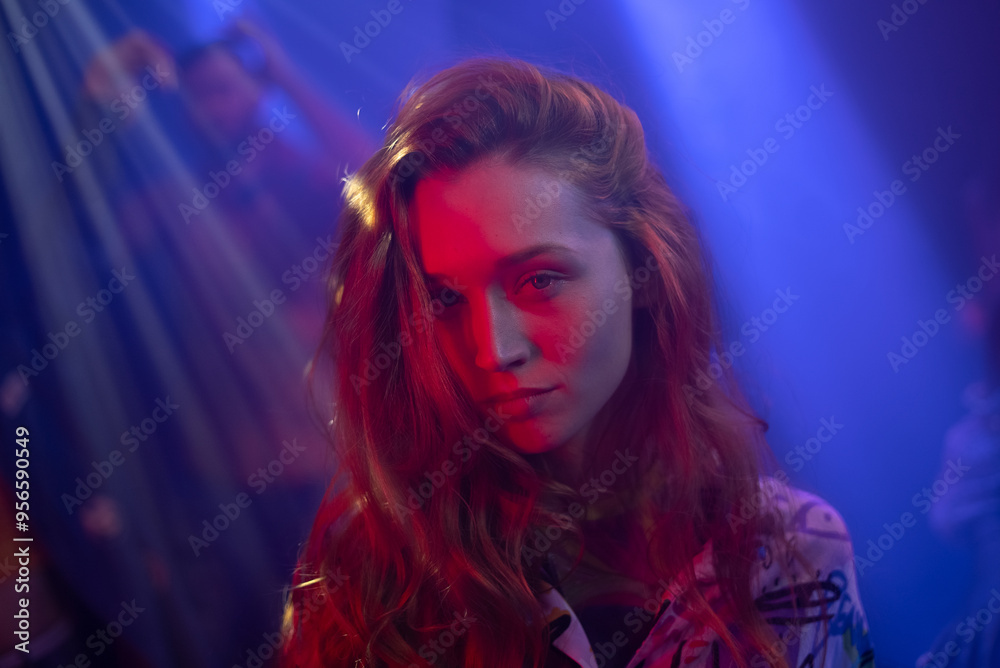 Wall mural portrait of a overjoyed young woman dancing at the modern night club in the background of a crowd