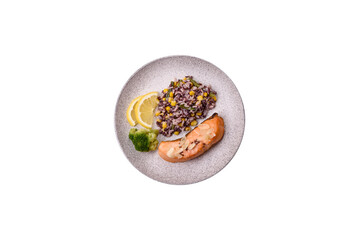 A piece of boiled salmon with rice, broccoli, salt and spices