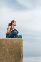 Woman sitting writing in a notebook or diary, outdoors