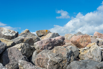 Pile of boulders. sea defence against a blue sky background