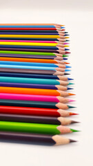 Colorful sharpened pencils are lined up on the table.