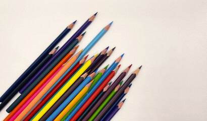 Colorful sharpened pencils are lined up on the table.