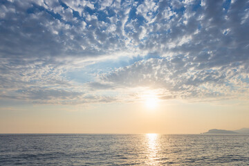 Coastal landscape with sea water under sunset sky