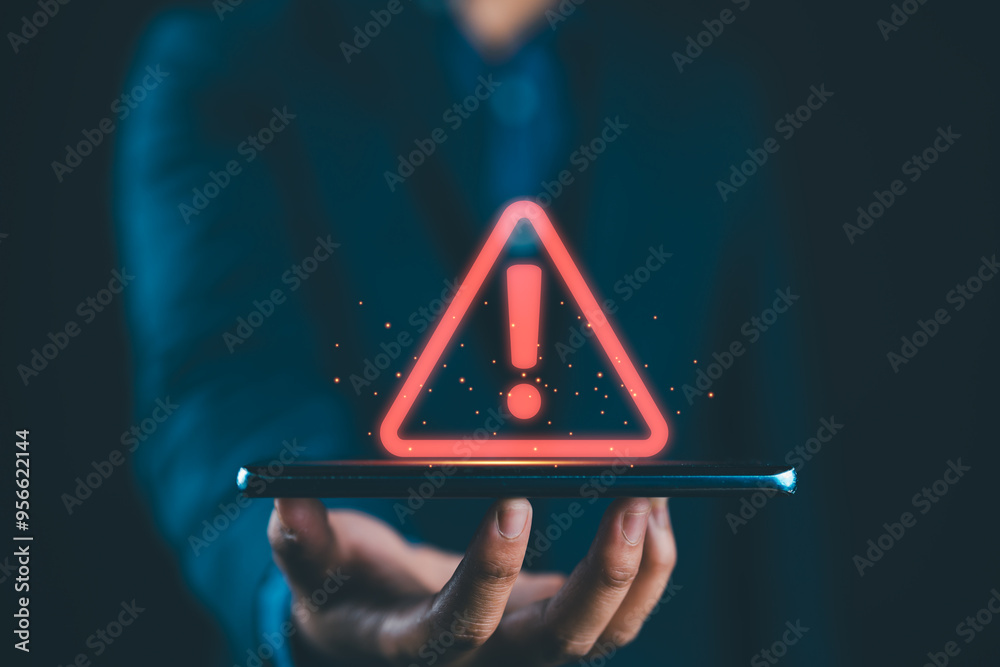 Poster businessman holding glowing red triangle caution warning exclamation sign for notification error and