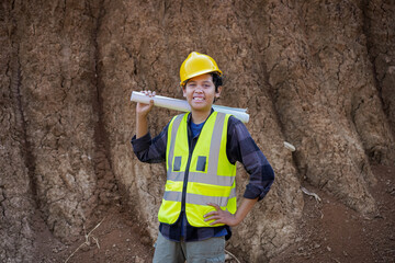 young male construction worker carrying blueprints, reading and analyzing them