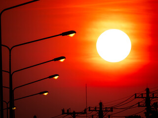 Sunset in The Red Sky near The Lights from Silhouette Electric Poles