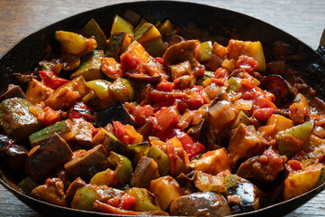 Homemade ratatouille in wok mixture of green and red bell peppers, zucchini or courgettes, tomatoes