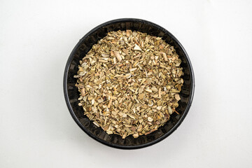 A bowl of herbs and spices is shown in a black bowl