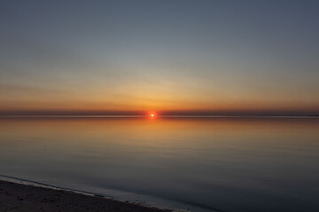 The sun sets on the water. Sunset and calm.