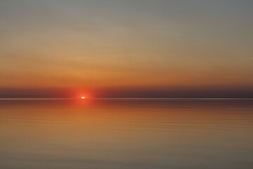 The sun sets on the water. Sunset and calm.