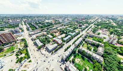 Aerial city view with crossroads and roads, houses, buildings, parks and parking lots, bridges. Helicopter drone shot. Wide Panoramic image.
