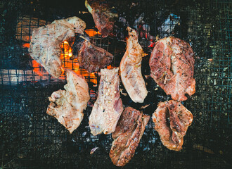 Grilled Meat on Barbecue, Closeup of Juicy Steaks and Pork Cooking Over Open Fire, High-Quality BBQ Stock Image for Food Photography and Culinary Concepts.