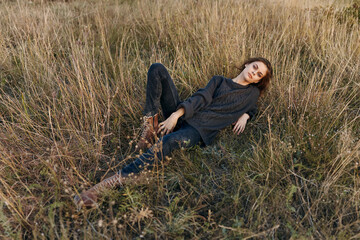 Serene woman relaxing in tall grass field with legs extended in peaceful solitude