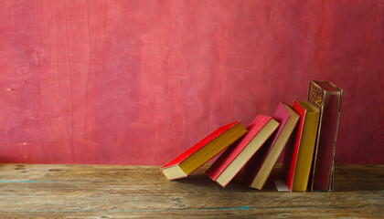 Row of red books on red grungy background, reading, learning, education or home office concept....