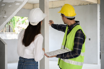 Female civil engineer with personal safety equipment check and consult with construction site...