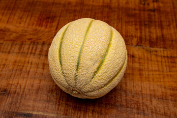 Charentais Melon Heirloom, french melon widely popular for its sweet and refreshing fragrance Bright orange, super sweet flesh, on a wooden rustic country table