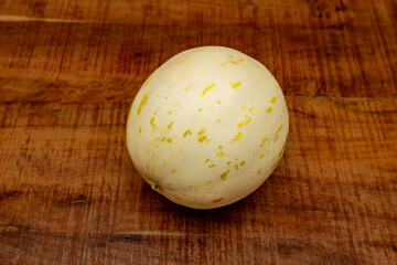 Snow Leopard Melon cream coloured skin with green spots and streaks, white flesh with crunchy texture, bright flavour, super sweet with undertones of honey and pear, on a wooden rustic country table