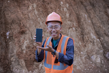 a young asian male construction worker makes a mobile phone video call and reports on his work results