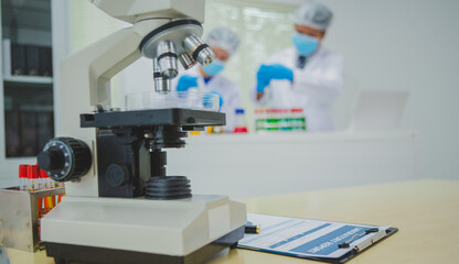 In this chemical experiment, two researchers collaborate to mix reactants, carefully observe changes such as color shifts or gas production, and analyze results, demonstrating principles of chemistry