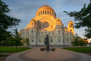 Monument to Admiral Fyodor Ushakov on the background of the Naval Cathedral of St. Nicholas (Naval St. Nicholas Cathedral) on a sunny summer morning, Kronstadt, St. Petersburg, Russia