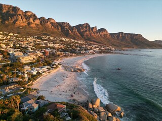 Fototapeta premium Golden hour view of Camps Bay beach and surrounding mountains in Cape Town, South Africa