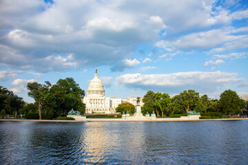 The United States Capitol building reflected on the reflection pool on a sunny day at nation mall,...