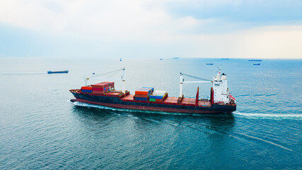 Fototapeta premium Rear view cargo container ship. Business logistic transportation sea freight, Cargo ship, Cargo container in deep sea port at industrial estate for import export around in the world