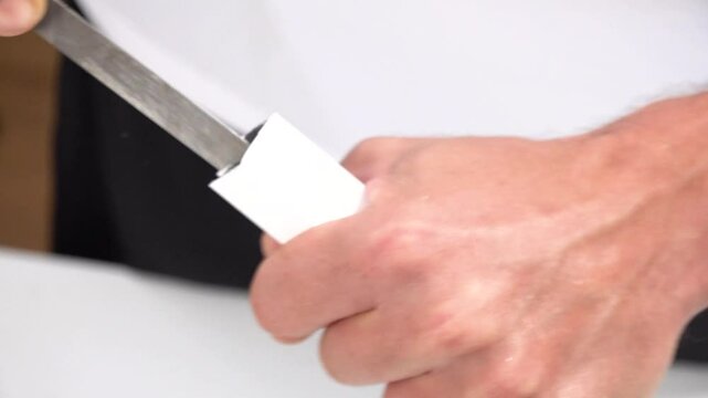 Close up view of rasping cutten edges of aluminum shape with a file for smoothing.
