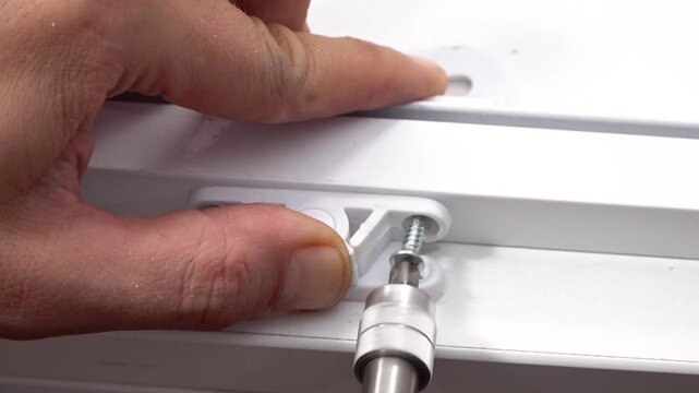 Close up view of snap lock mechanism screwing to fly screen window with an electric drill.