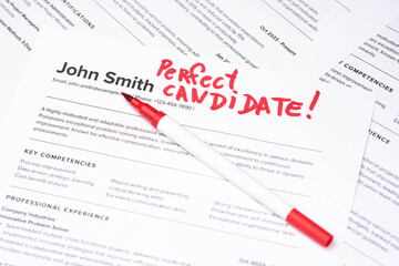 Fototapeta premium Fake mock CV (curriculum vitae) resume for John Smith, selected by HR as the perfect candidate for a job. Concept of job search, employee selection, recruitment process, work and hiring.