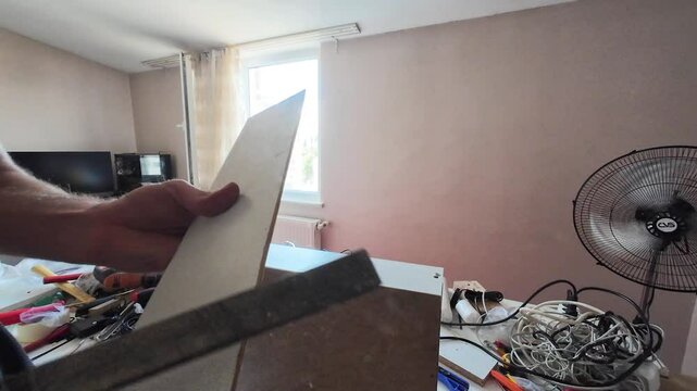 Close up view of carpenter rasping a wooden board.