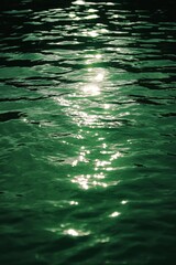 Sunlight reflecting on a green water surface with ripples, giving a shimmering and relaxing effect on the observer.