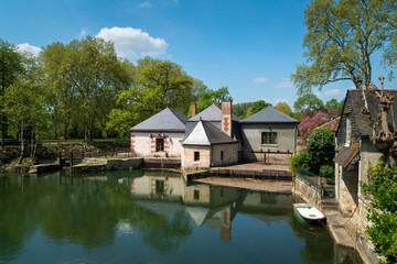 Obraz premium View from the observation deck on the Endr River to the dam and ancient residential buildings on a sunny summer day, Azay-le-Rideau, Indre-et-Loire, France