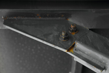 iron metal column, steel rafters. Roof bridge structure. rusty painted Bolts and nuts joining two steel girders together. weld seams on ferrum sheets. close up image. © Maxim Chuev
