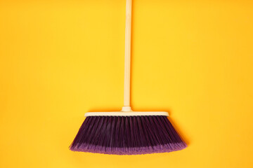 One cleaning broom on orange background, top view