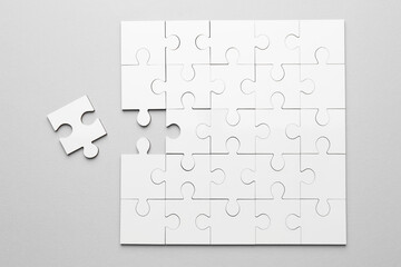 White puzzle pieces on grey background, top view