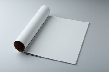 Open magazine with blank page on grey background. Mockup for design