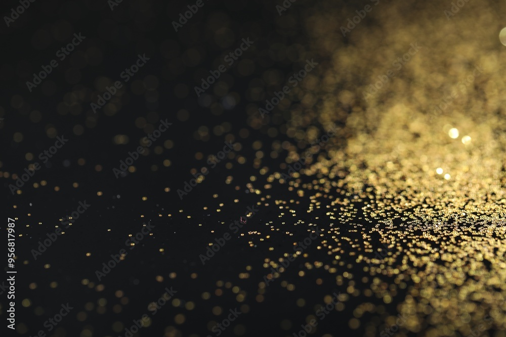 Sticker Beautiful shiny golden glitter on black background, closeup