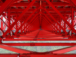 Symbolic red-colored steel frame of Aizhai Bridge, a suspension bridge across the valley in Aizhai, western Hunan, China. One of highest and longest suspension bridges in world.