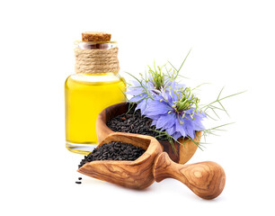Black cumin on white background closeup in wooden spoon. Black cumin oil.