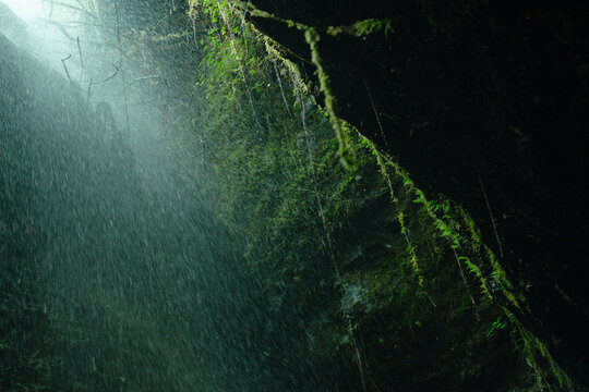 Creative and artistic composition in the Cueva del Esplendor, cave of splendor, Jardin, Jard&iacute;n, Antioquia, Colombia. Dark abstraction with rain falling on a rock and droplets in a ray of light.