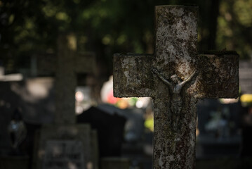 
CEMETERY - An old crucifix with a figurine of Jesus on a tombstone
