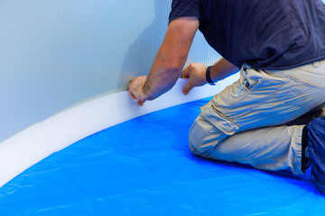 Pool liners are protected by durable foam construction installed by worker in ground pool