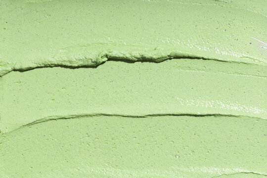 Swatch texture of green cream cray kaolin cosmetic mask for face and body, background. Copy space