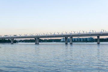 Evening cityscape with automobile bridge over river