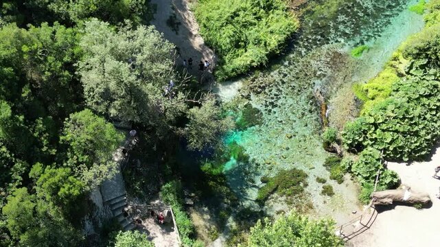 River coast dron bird view in Blue eye river, Albania. Green Seaweed leaves in Turquoise and green water river Bistrice scenic aerial view in Muzine, Finiq, Albania, Europe.